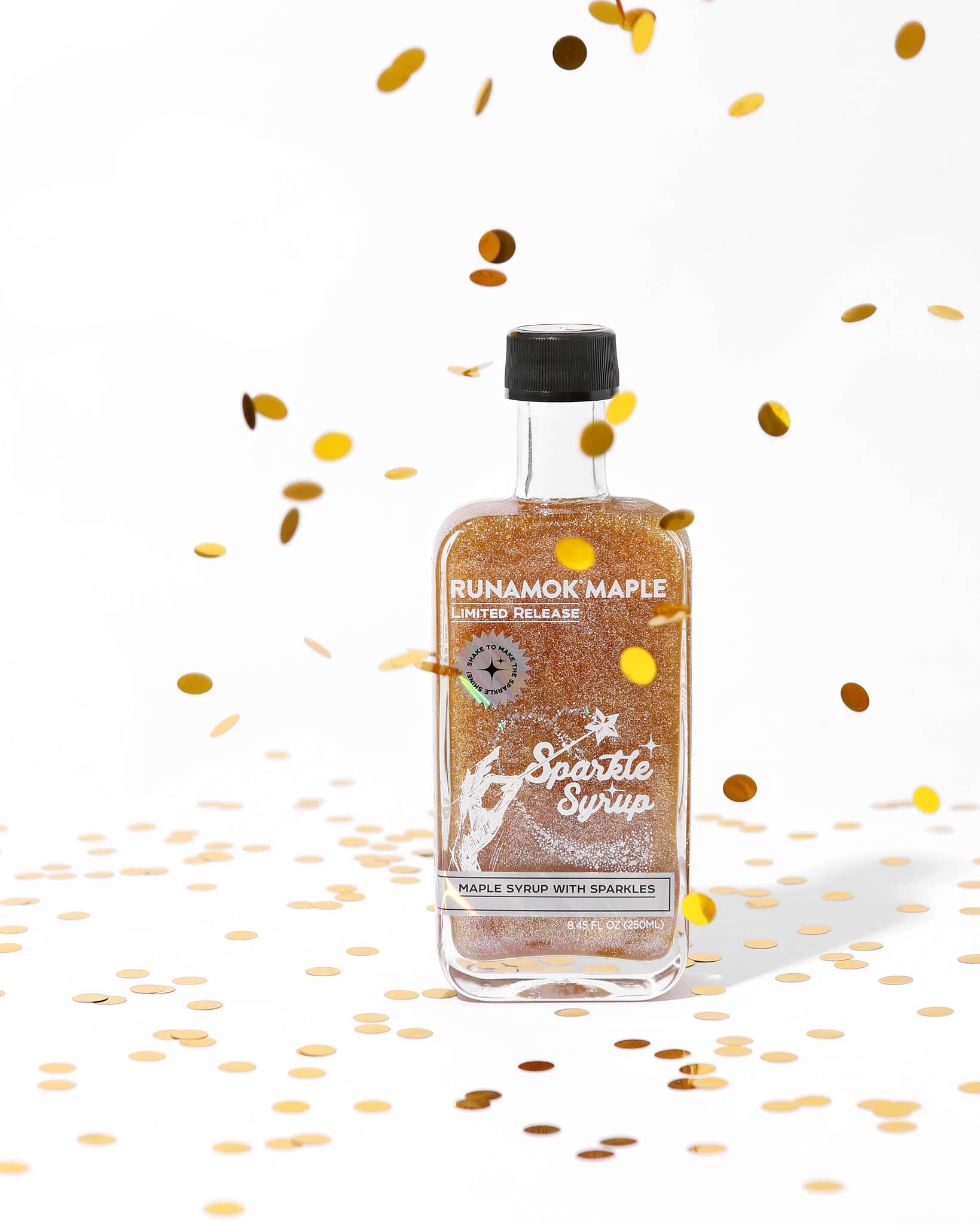 Bottle of Rumamok Maple Sparkle Syrup with confetti on a white background