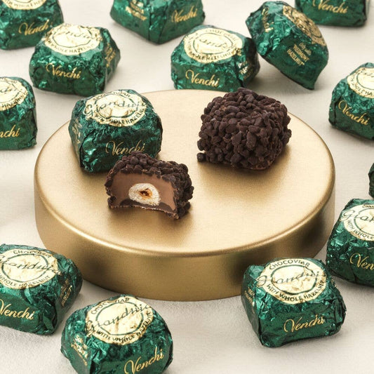 Venchi chocolate truffles on a gold stand with green wrappers.