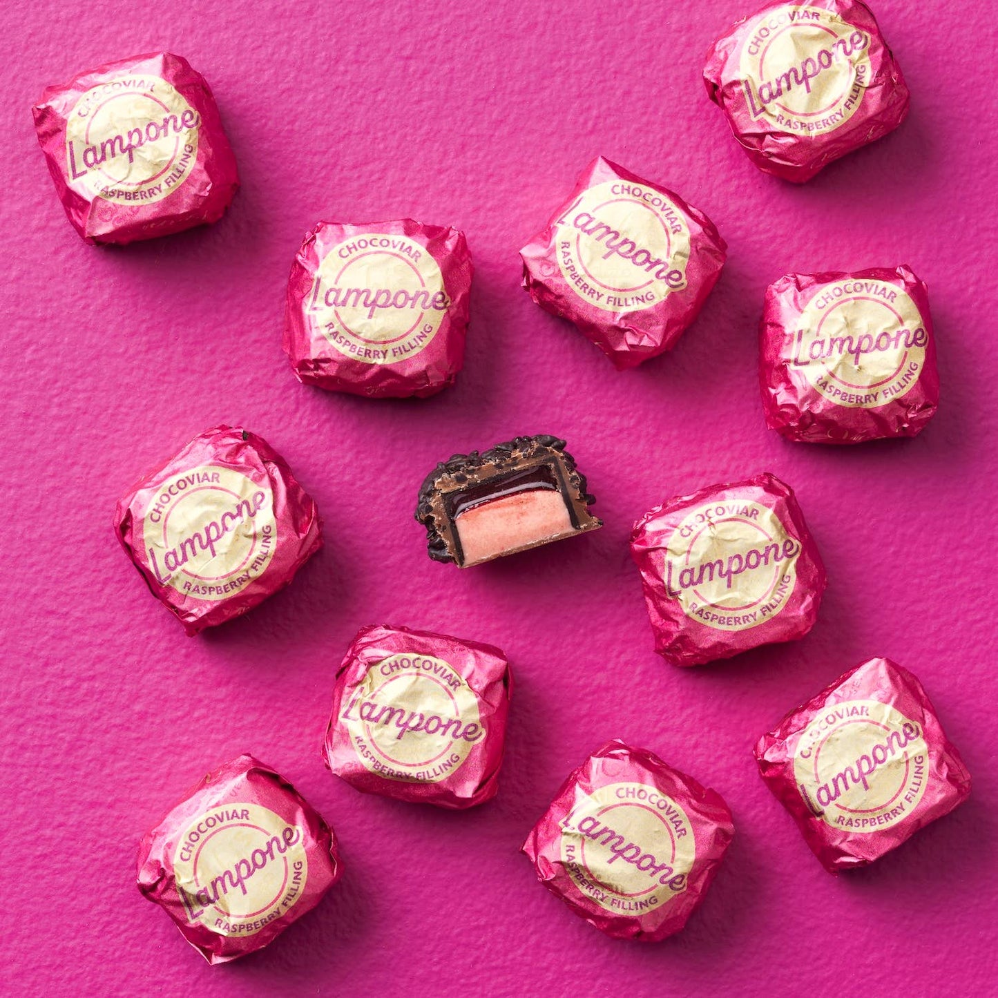 Pink candy wrappers with 'Lampone' branding on a pink background