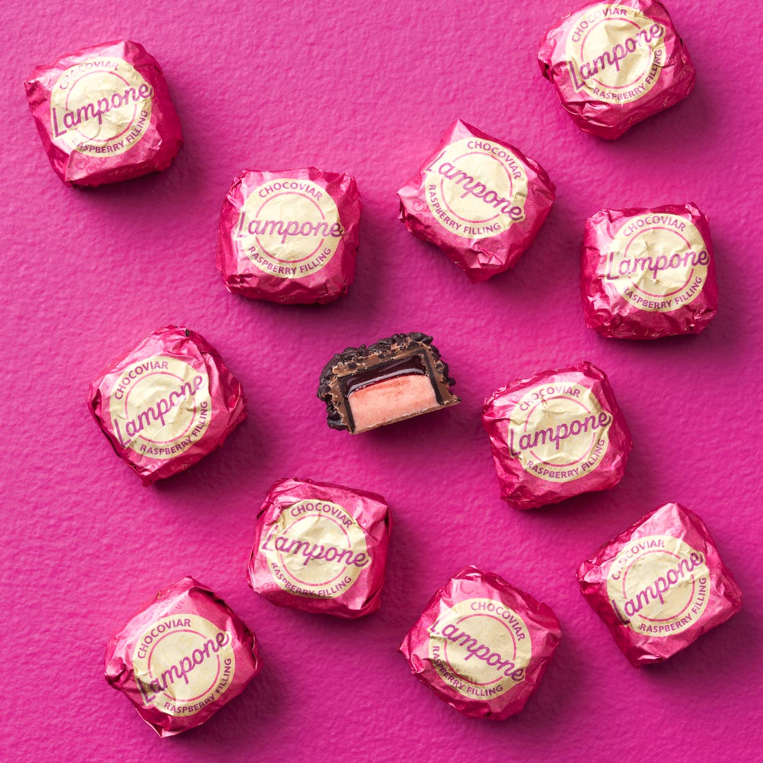 Pink candy wrappers with 'Lampone' branding on a pink background