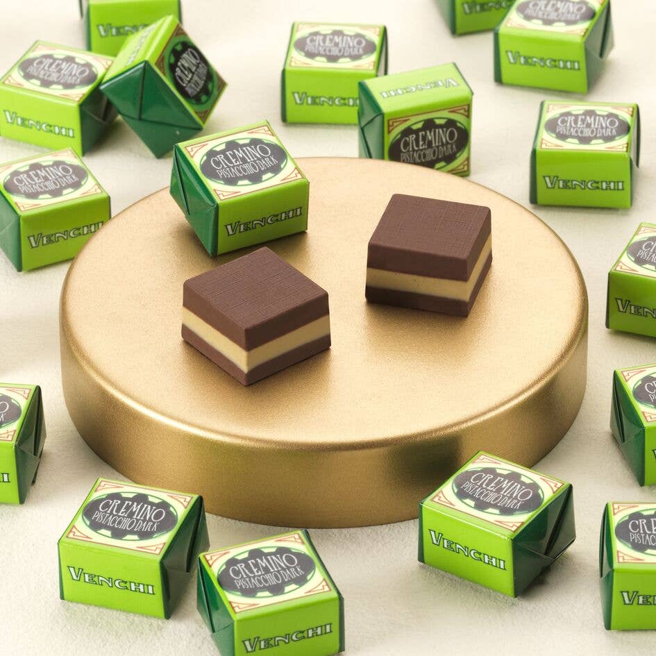 Chocolate bars on a gold plate with green boxes labeled 'Vesuvio' in the background.