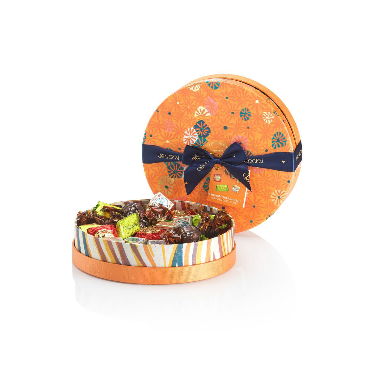 Round candy tin with colorful design and bow on a white background