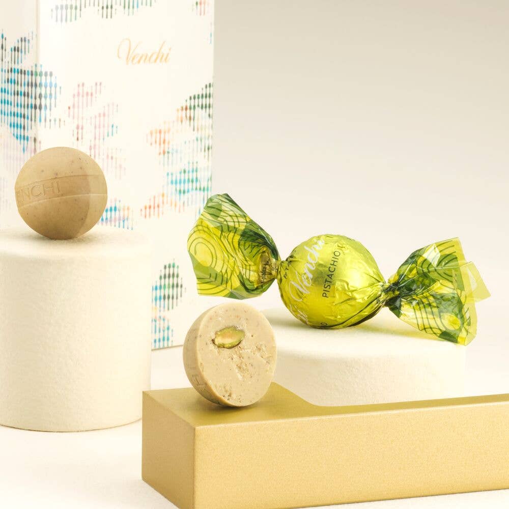 Green lollipops with decorative paper on a white surface with a colorful abstract pattern in the background.