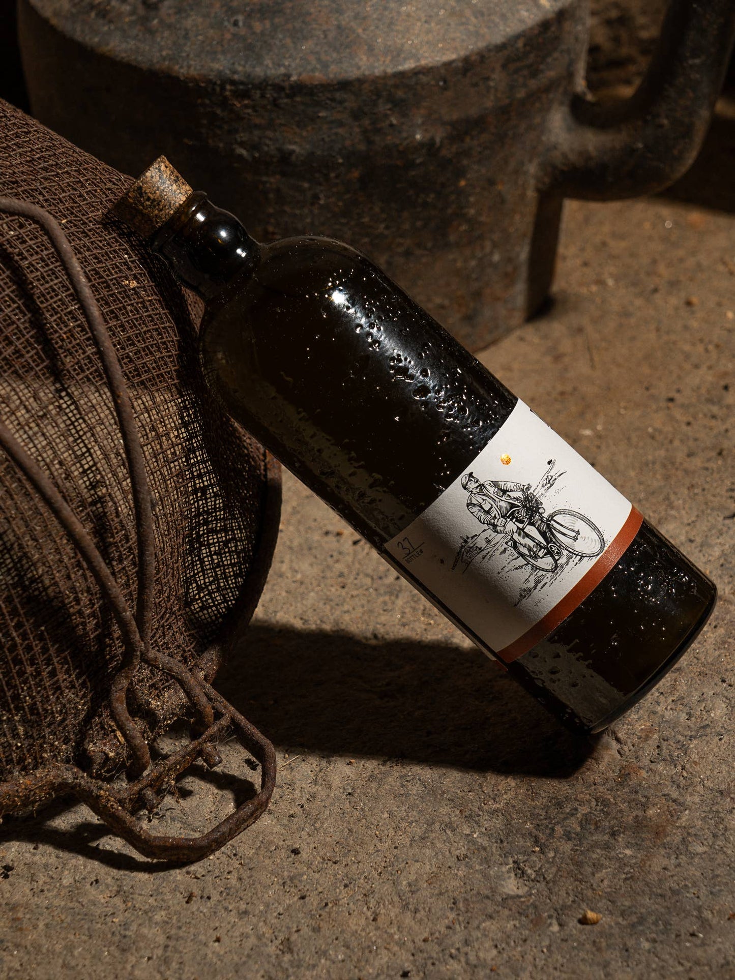 Wine bottle with a label on a concrete surface next to a woven bag